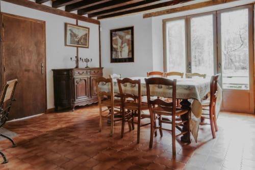 une salle à manger avec une table et des chaises dans l'établissement Le Moulin Barbotte La convivialité en pleine nature, à Nesle-la-Reposte