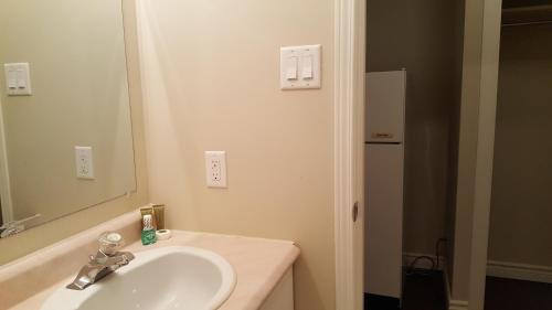 une salle de bain avec un lavabo et un miroir dans l'établissement Duvernay Studios and Suites, à Gatineau