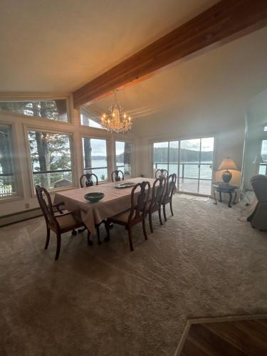 a dining room with a table and chairs and windows at Captains View in Kodiak