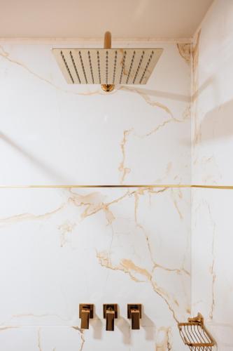 a bathroom with white marble walls and a chandelier at Tequendama Suites Bogota in Bogotá