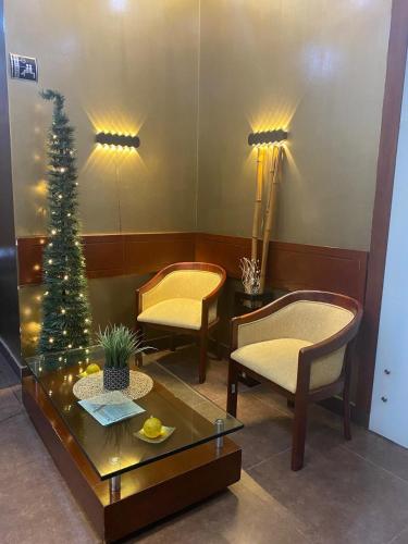 a living room with two chairs and a christmas tree at Tequendama Suites Bogota in Bogotá