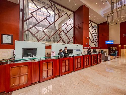 a lobby with a counter with two people standing at it at Tequendama Suites Bogota in Bogotá
