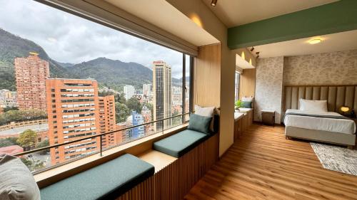 a bedroom with a balcony with a view of a city at Tequendama Suites Bogota in Bogotá