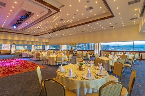 a banquet hall with tables and chairs and windows at Tequendama Suites Bogota in Bogotá