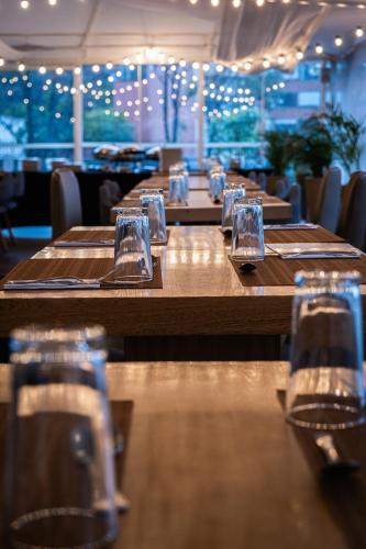 a row of wooden tables in a restaurant with wine glasses at Tequendama Suites Bogota in Bogotá