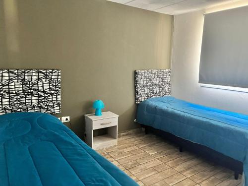 1 Schlafzimmer mit 2 Betten und einer Tafel in der Unterkunft Adonay VGB in Villa General Belgrano