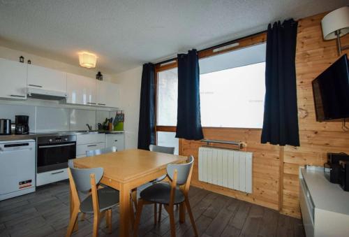 - une cuisine avec une table et des chaises en bois dans l'établissement Résidence Les Hameaux I - 2 Pièces 4/5 pers - LES HAMEAUX 1- PLAGNE VILLAGES MAE-9294, à Aime La Plagne