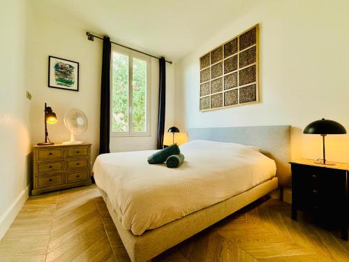 une chambre avec un lit avec un ours en peluche dessus dans l'établissement Superbe Villa - Cannes Centre -Proche Palais des Festivals et Plages, à Cannes
