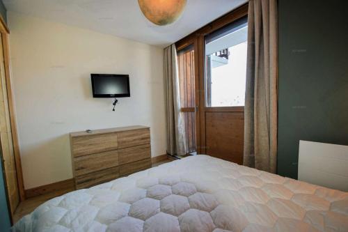 une chambre avec un lit, une télévision et une fenêtre dans l'établissement Résidence Les Hameaux Ii - Appartement 2 pièces + cabine 6 pers - LES HAMEAUX 2 - PLAGNE VILLAGES MAE-4851, à La Plagne Tarentaise