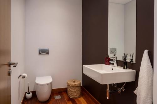 a bathroom with a white sink and a toilet at Piscina fantástica no centro da cidade! in Funchal