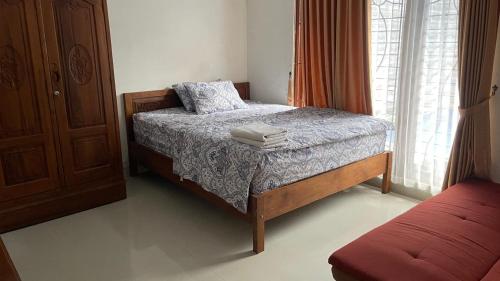 a bedroom with a bed and a window at Griya Kania Merapi in Sleman