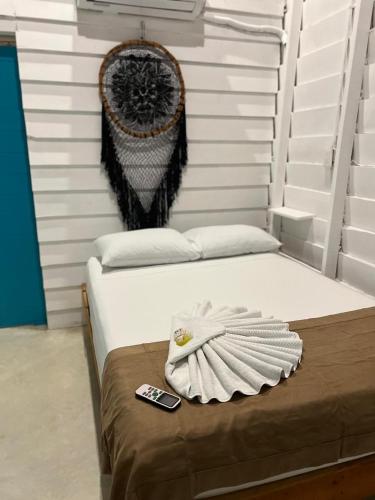 a bedroom with a bed with a remote control on it at Hotel AKBAL Holbox in Holbox Island