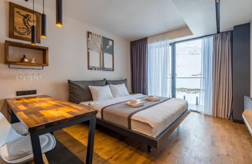 グダウリにあるAtrium New Gudauriのベッドとテーブルと窓のある寝室