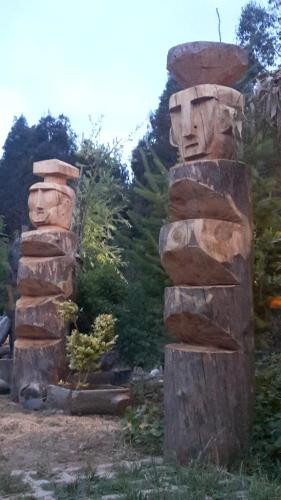 two stone statues of heads standing next to each other at Cabañas Rukas Licantén in Licantén