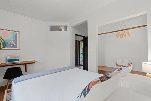 a white bedroom with a bed and a window at Villas Vibras in Playa Avellana