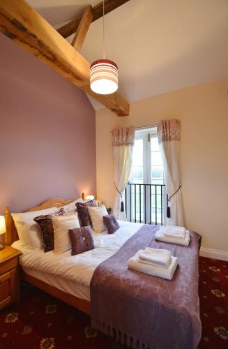 a bedroom with a large bed with two towels on it at The Old Red Lion in Thame