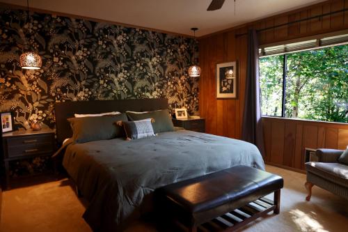 a bedroom with a bed and a chair and a window at Mountain Mangrove, A Quiet Mountain Retreat in Lake Toxaway