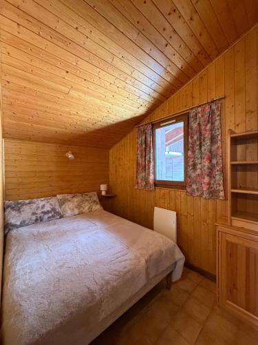 une chambre avec un lit dans une cabane en bois dans l'établissement Au cœur des pistes, à Saint-Gervais-les-Bains