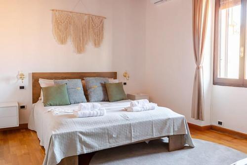 a bedroom with a bed with white sheets and green pillows at Albore Guest House in Sassari