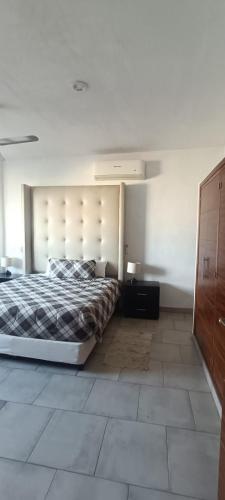 a bedroom with a large bed and a wooden cabinet at Dep #1 Basilio in Puerto Vallarta