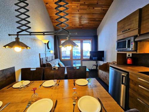 une cuisine et une salle à manger avec une table et des chaises dans l'établissement Résidence Le De 4 - Appartement 2 pièces pour 6 personnes de 35m² MAE-3881, à La Plagne Tarentaise