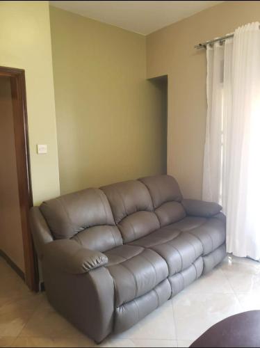 a brown leather couch in a living room at Reyahapartment in Entebbe