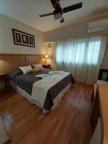 a bedroom with a large bed with a ceiling fan at Hotel Alma di Mare MDP in Mar del Plata