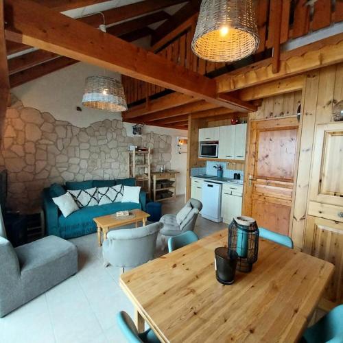 Il comprend un salon avec une table en bois et une cuisine. dans l'établissement Résidence Means - Superbe T2 avec mezzanine pour 9 personnes sur la station du Réallon MEANS1 MAE-8001, à Réallon