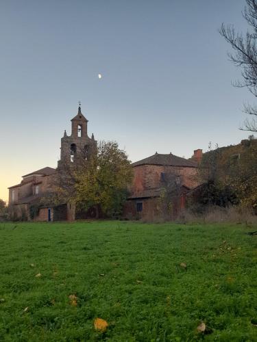 an old building with a tower on top of a field at Arzipreste II Casa del Ama in León