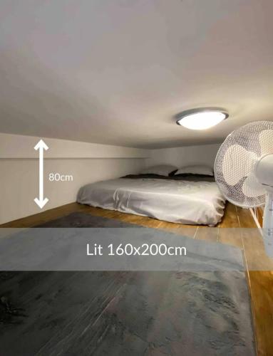 une chambre avec un lit et une lumière au plafond dans l'établissement Studio NYO Vieux Port, à Marseille