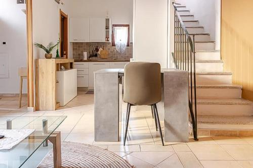 a kitchen with a table and a chair and stairs at Albore Guest House in Sassari