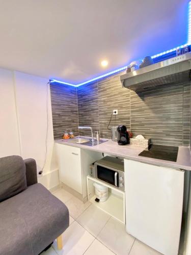 une cuisine avec un évier et un canapé dans une chambre dans l'établissement Studio NYO Vieux Port, à Marseille
