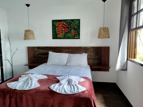 two towels on a bed in a room at Pousada Ecomar in Florianópolis