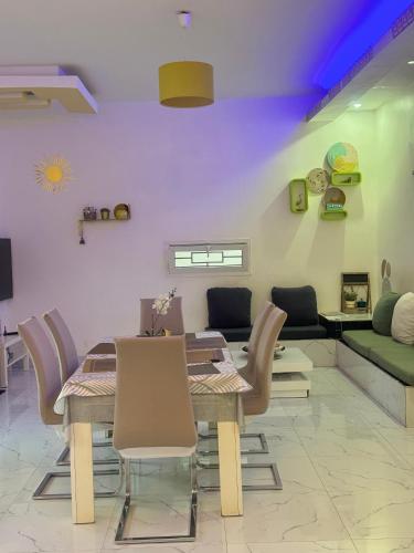 a dining room with a table and chairs and a couch at Grace house jacuzzi in Saly Portudal