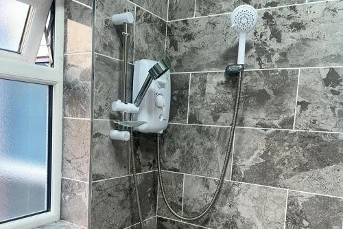 a shower with a blow dryer on a stone wall at City Chic Retreat In Birmingham in Birmingham