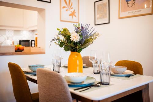 a dining room table with a vase of flowers on it at BoRa Apartments in Villach