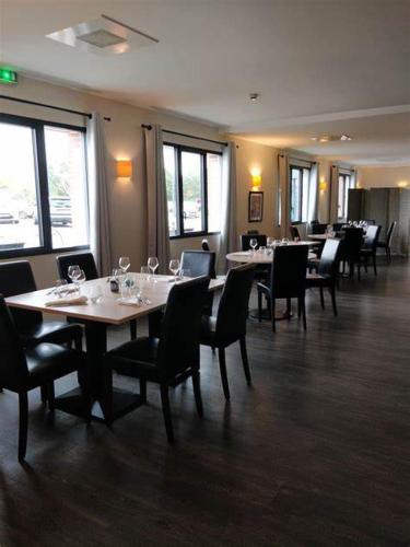 une salle à manger avec des tables, des chaises et des verres à vin dans l'établissement La Grande Baie, à Bourgneuf-en-Retz