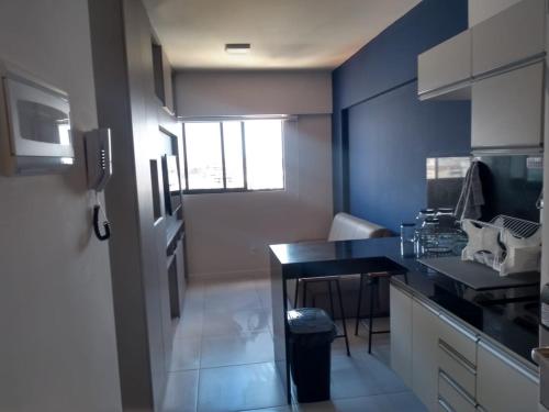 eine Küche mit einer schwarzen Arbeitsplatte und einem Tisch in der Unterkunft Flat Por Temporada no Edifício Time Maceió-AL in Maceió