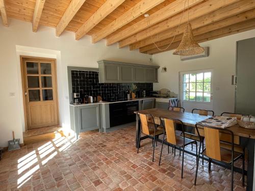 une cuisine avec une table et des chaises dans une pièce dans l'établissement Manoir de famille Beausoleil, à Allonnes