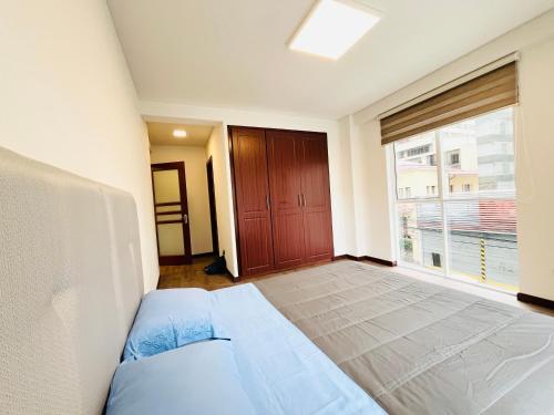 ein Schlafzimmer mit einem Bett und einem großen Fenster in der Unterkunft Nuevo Departamento en Sopocachi in La Paz