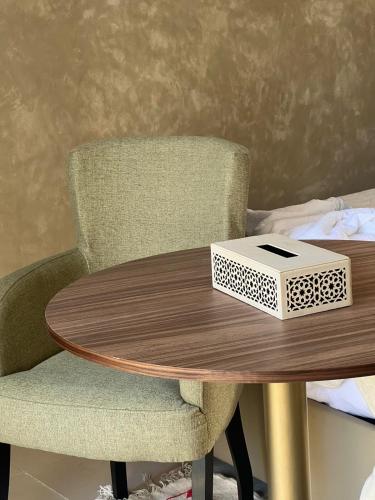 a wooden table with a chair and a box on it at RIAD REDWAN in Marrakech