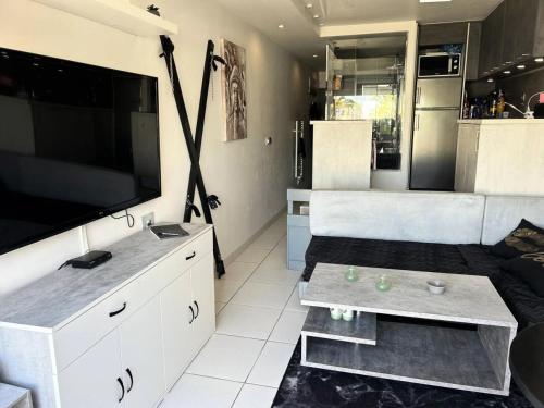 un salon avec une grande télévision à écran plat dans l'établissement Résidence Port Nature Colline 8 - Joli Studio T2 - 2 personnes Port Nature Colline 8 Rez de Chaussée MAE-5301, au Cap d'Agde