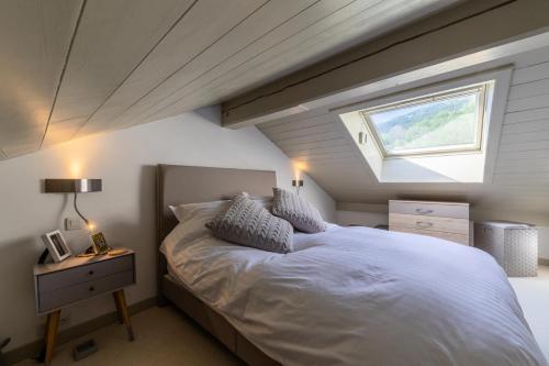 um quarto com uma grande cama branca e uma janela em Résidence Bergerie Des 3 Vallees C - Joli appartement 3 pièces 4 personnes situé sur Les Allues dans un quartier calme MAE-7391 em Les Allues