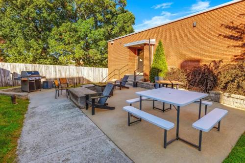 a patio with tables and chairs and a grill at The West End Flats Hotel in Roanoke