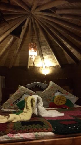 a room with a bed in a room with a ceiling at Cabañas Rukas Licantén in Licantén