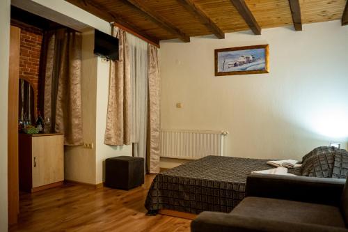 a bedroom with a bed and a couch in a room at Matsurev Han in Bansko