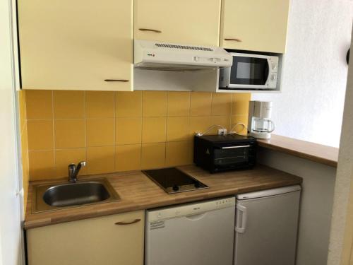 une petite cuisine avec un évier et un micro-ondes dans l'établissement Résidence Hauts De Peyragudes Mp - T2/6pers -HAUT DE PEYRAGUDES B12- Peyresourde MAE-7551, à Germ