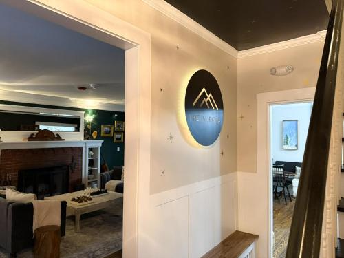 a living room with a fireplace and a clock on the wall at The Aurora Inn & Cottages in Bartlett