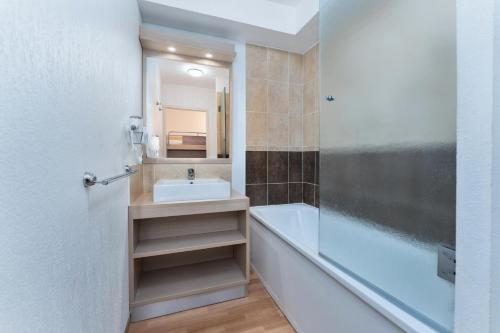 une salle de bain avec un lavabo, une baignoire et un miroir dans l'établissement Résidence Les Terrasses Du Soleil D'or - Studio 4 personnes pour un séjour skis aux pieds MAE-7631, aux Orres