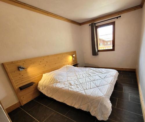 ein Schlafzimmer mit einem Bett und einem Fenster in der Unterkunft Résidence Le Criterium - Résidence Le Critérium 3Chalet E Appartement 4 MAE-7721 in Lanslebourg-Mont-Cenis